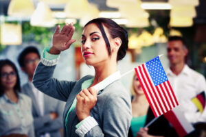 Patriotic businesswoman standing with USA flag in front of colleagues